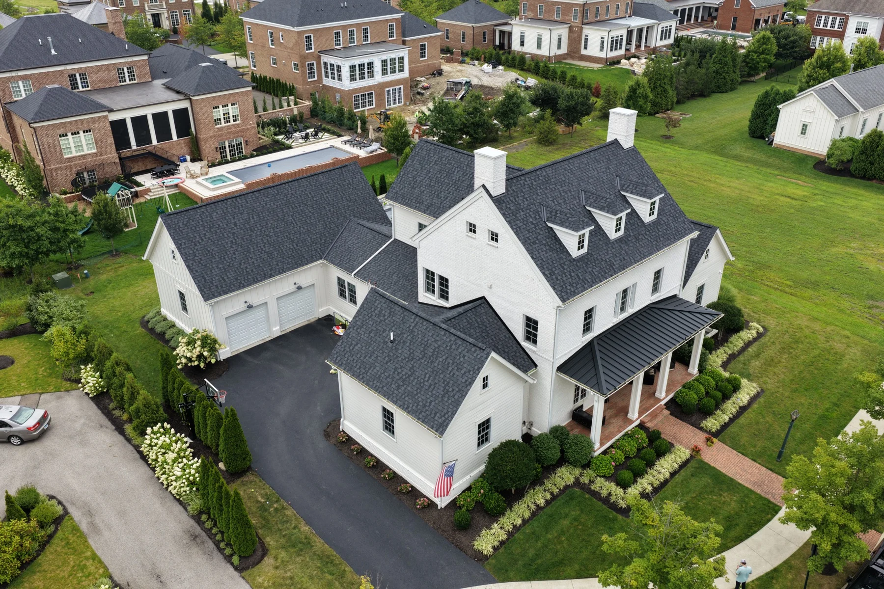 Completed dark shingle roof on a white home, photographed from above
